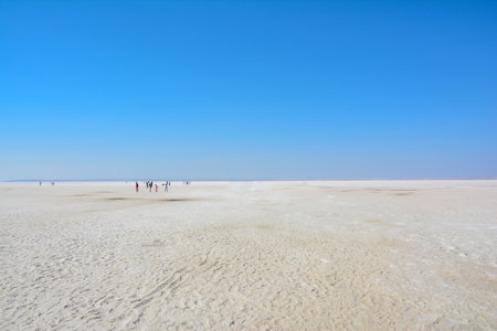 Tourists walking in the white sand dunes of Salar de Uyuni, Boliviaの写真素材