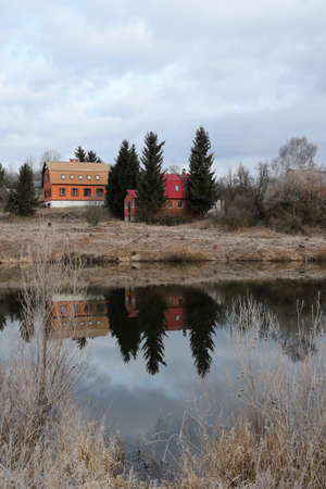 Reflection of houses and trees in the waterの写真素材