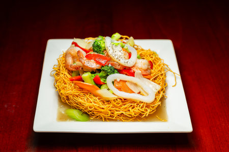 Seafood Stir-Fry on Crispy Noodle Basketの写真素材