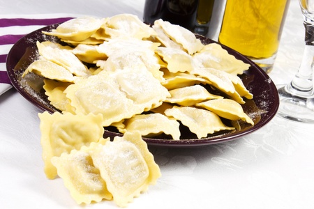 ravioli in the dish on a white background with oil and utensilの写真素材
