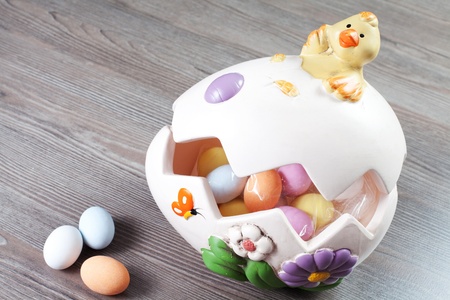colorfull eggs in the egg shaped eith chick on the wood table