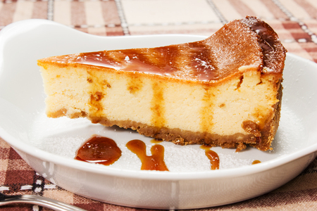cheesecake with caramel sauce on the tableの写真素材