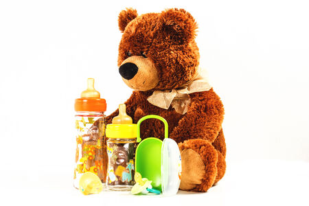 teddy bears and baby bottles and pacifiers for a child on the white backgroundの写真素材