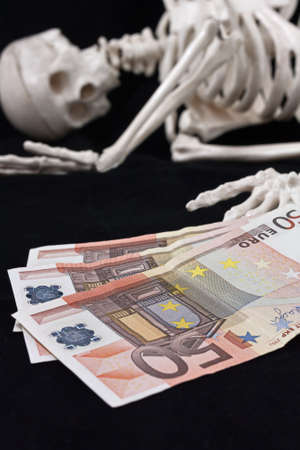 Skeleton and money, sometimes money can be harmful to health