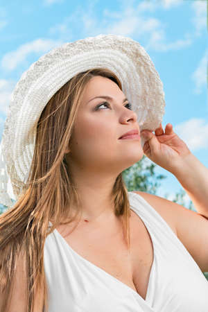 blonde girl with white hat in green environmentの写真素材