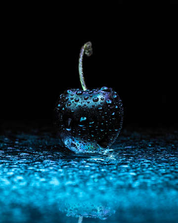 wet cherry in blue lightの写真素材