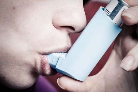 Woman inhaling asthma spraysの写真素材