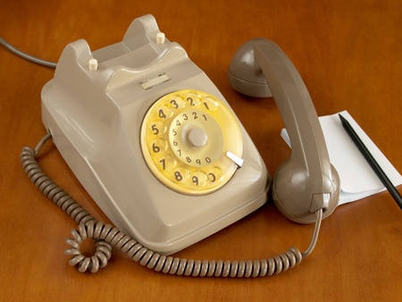 vintage telephone on wood table and notesの写真素材