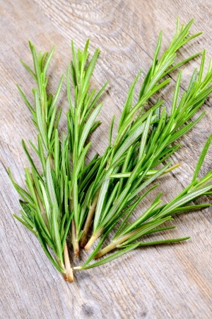 fresh sprig of rosemary on wooden tableの写真素材