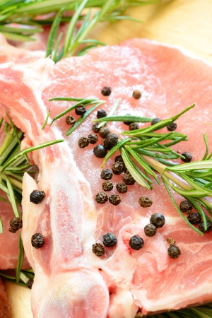 pork chops with fresh rosemary on the wooden cutting boardの写真素材