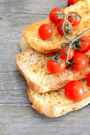 dried bread called freselle, soaked in the water to be served with olive oil and sliced tomatoの写真素材