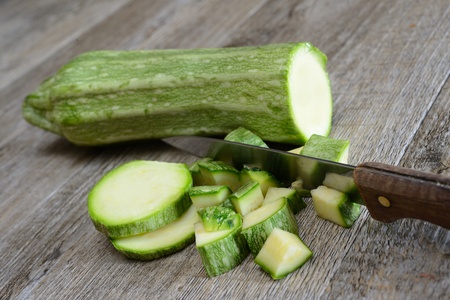 long green zucchini sliced on wooden tableの写真素材
