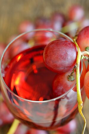 rose wine and grapes on old wooden tableの写真素材