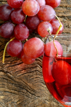 rose wine and grapes on old wooden tableの写真素材