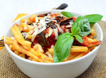 italian sicilian  homemade pasta with eggplant and pecorino cheese and tomato sauce called "pasta alla norma"の写真素材
