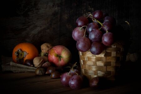 autumnal fruits on dark wooden backgroundの写真素材