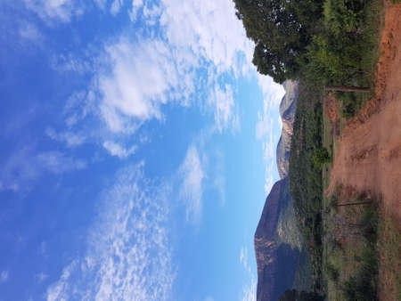 Rural road on the middle with scenic view of mountainsの写真素材