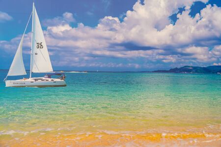 Sailboat in the sea in the evening sunlight over beautiful big mountains background, luxury summer adventure, active vacation in Mediterranean sea, Turkeyの写真素材
