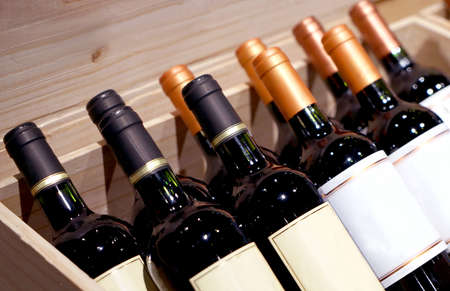 Wine shop. Closeup shot of wineshelf. Bottles lay over straw.の写真素材