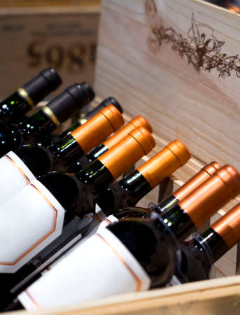 Wine shop. Closeup shot of wineshelf. Bottles lay over straw.の写真素材
