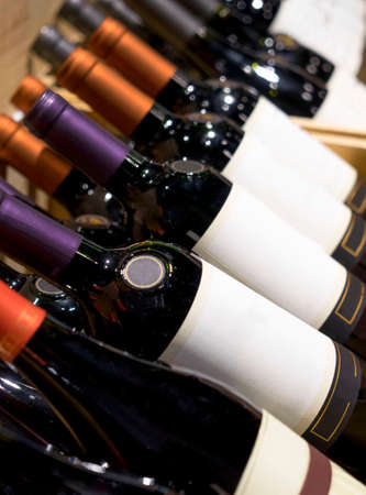 Wine shop. Closeup shot of wineshelf. Bottles lay over straw.の写真素材
