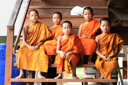 Mea Hong Son, Thailand-August 17, 2015: Novice monks sitting on stairs at wooden monk's houseの素材