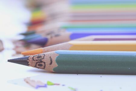 Colorful pencils and colorful pencils shavings on white background
