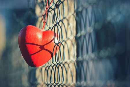 Love concept, heart shape hanging on metal fenceの素材