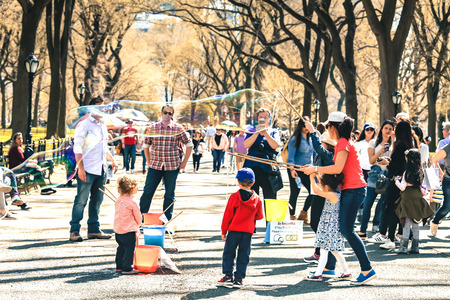 NEW YORK, USA - APRIL 15, 2016 : Children enjoy inflating huge soap bubbles at Central Park in springのeditorial素材
