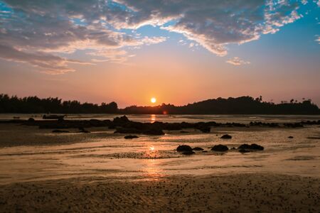 Selective focus on the sun during the sunset on the seaの写真素材