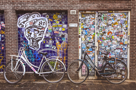 Amsterdam-Netherlands, April 15, 2017 : Bicycles parked on street in Amsterdam with background covered by advertising stickersのeditorial素材