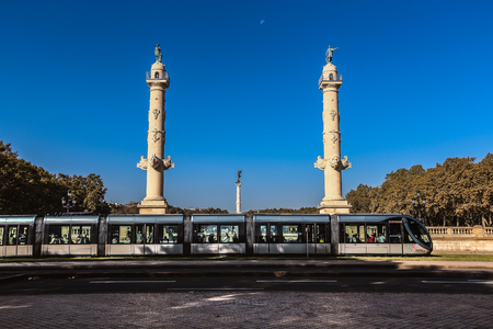 BORDEAUX, FRANCE - 19 JANUARY, 2017 : Tram is passing by the Girondin's column with blue skyのeditorial素材