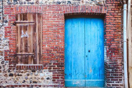 Old wooden Blue door and window in red brick wall in vintage style, Franceの写真素材