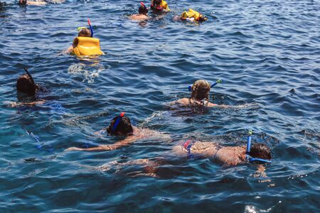 Tourists enjoy snorkelling in a tropical sea at Nusa, Bali, Indonesiaの写真素材