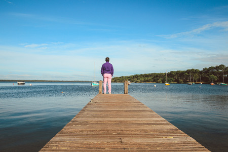 Back side of man stands alone at the edge of the bridge, vacation concept