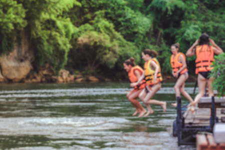 Blurred of group of friends jumping on the river kwai, Kanchanaburi during the vacation. Concept about vacations, leisure and funの写真素材