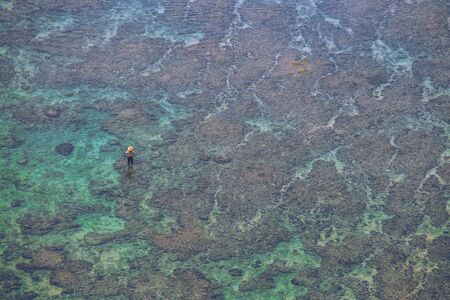 Selective focus on fisherman standing on the turquoise oceanの写真素材