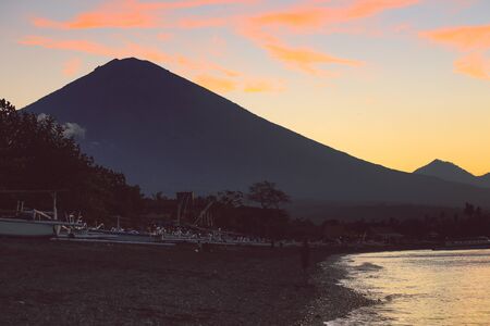 Amed black sand beach and volcano Agung at sunrise and sunsetの写真素材