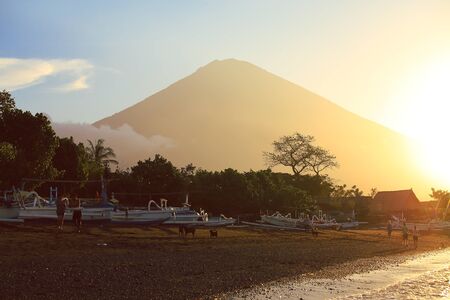 Amed black sand beach and volcano Agung at sunrise and sunsetの写真素材