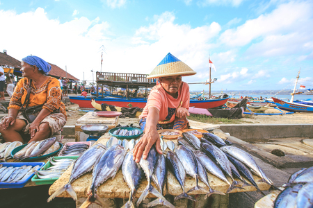 BALI, INDONESIA - AUGUST 8, 2017 : Balinese fishmonger sells fish in the morning market in Kedonganan - Passer Ikan, Jimbaran beachのeditorial素材