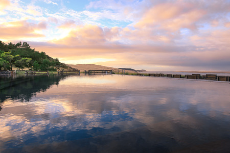 Morning colourful sky with it's reflection in water with la dune du Pyla on the backの写真素材