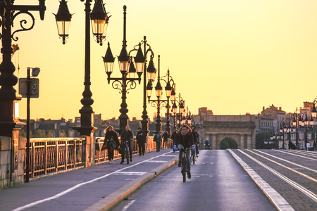 BORDEAUX, FRANCE - 1 NOVEMBER,  2017 : People riding bicycles on Pont de Pierre bridge in Bordeaux during the sunsetのeditorial素材