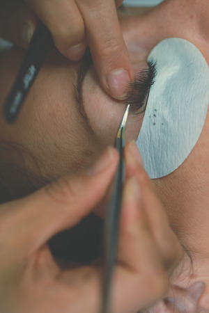 Eyelash Extension Procedure. Woman Eye with Long Eyelashes. Lashes. Close up, macro, selective focus