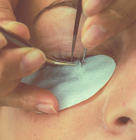 Eyelash Extension Procedure. Woman Eye with Long Eyelashes. Lashes. Close up, macro, selective focus