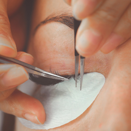 Eyelash Extension Procedure. Woman Eye with Long Eyelashes. Lashes. Close up, macro, selective focus