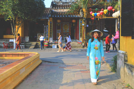 Hoi An, Vietnam - February 7, 2018 : Woman in Ao Dai dress walking on the street in Hoi an, Vietnamのeditorial素材