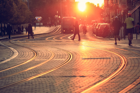 Selective ofcus on pavement, city street scene, people walking on street with tramway during the sunset in Bordeaux, Franceのeditorial素材