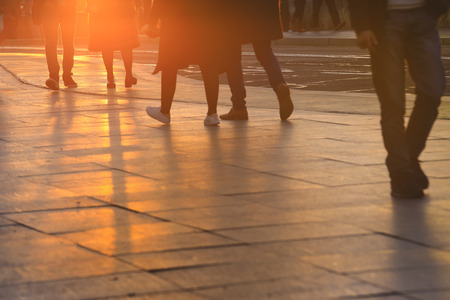 People crossing a road in New York City during sunset hoursの写真素材