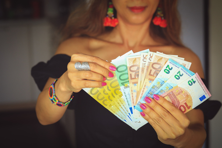 Happy young woman holding euro cash moneyの写真素材