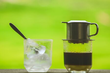 Drip Black Coffee in Vietnamese style with condensed milk on  table. Traditional method of making coffee.の写真素材